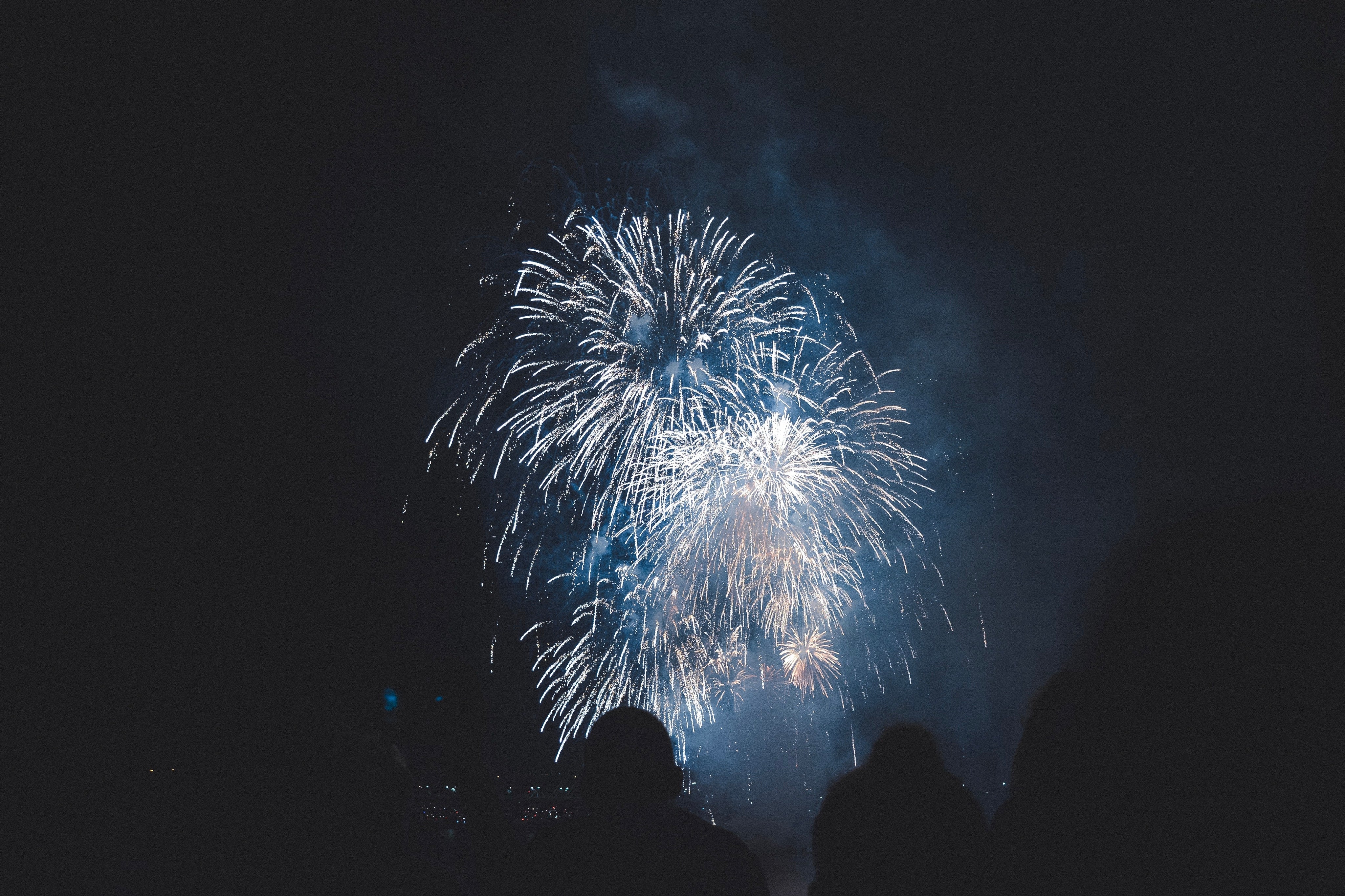 Silhouette of people watching a fireworks display